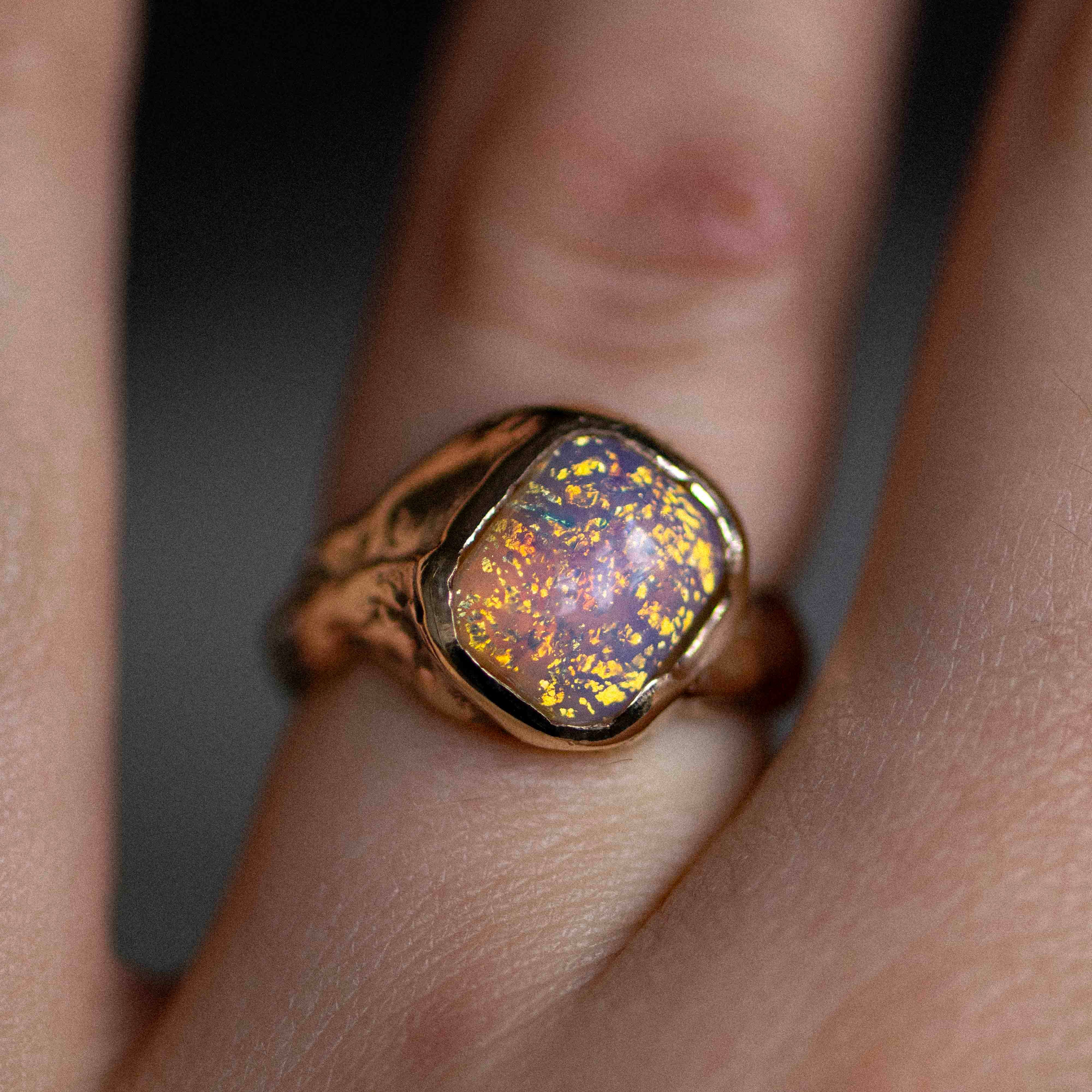 a gold and opal handmade ring on a woman's finger