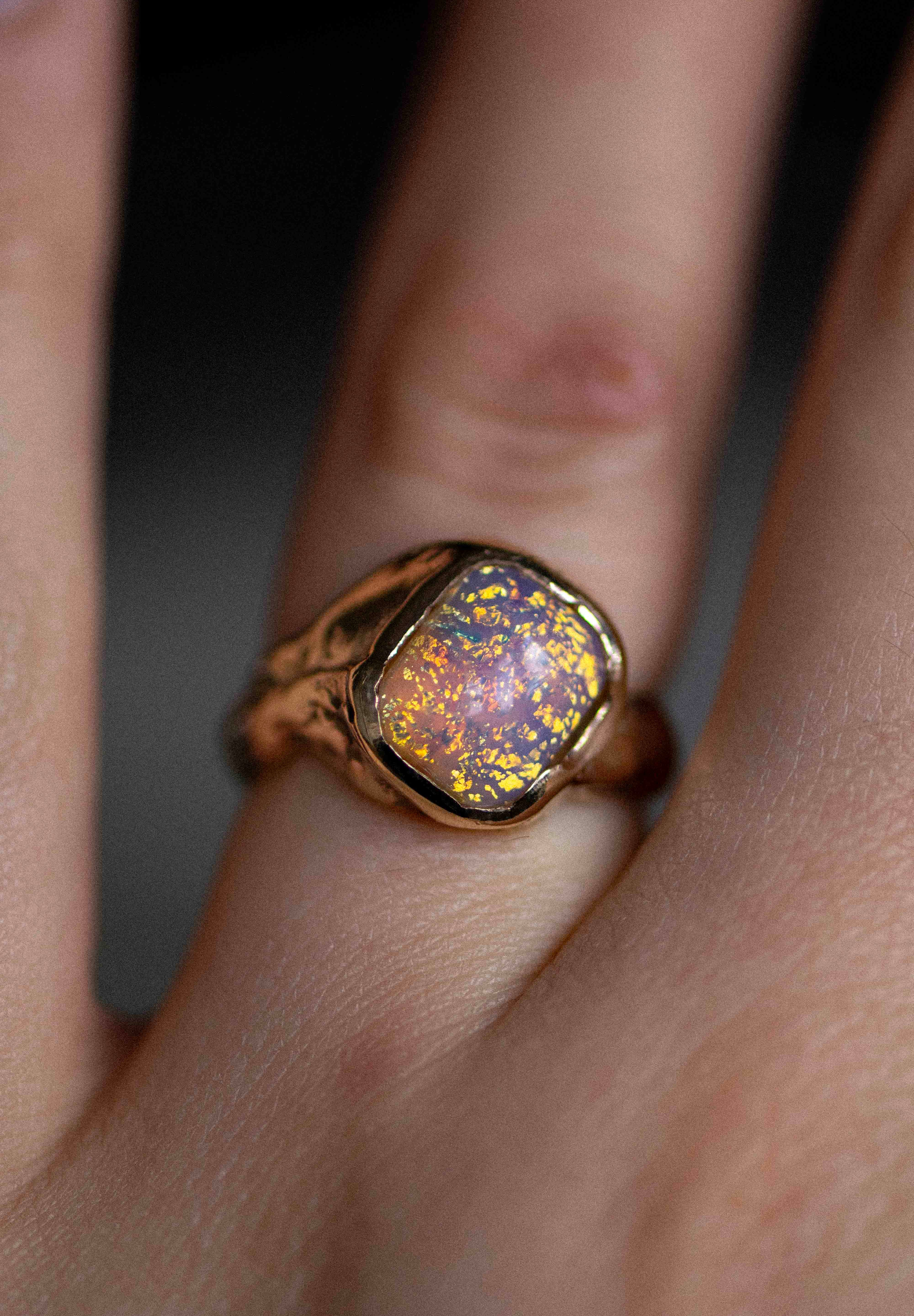 a gold and opal handmade ring on a woman's finger