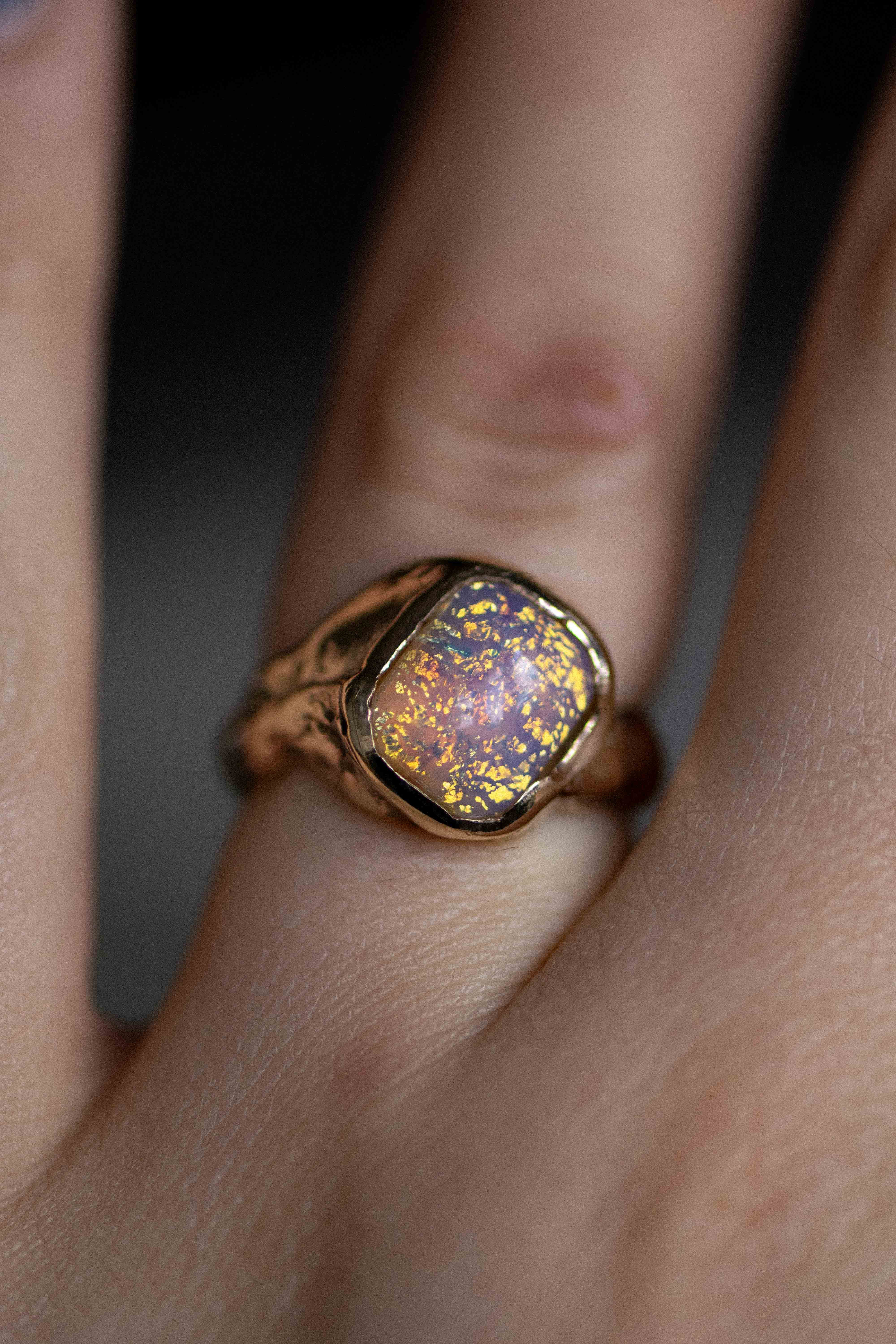 a gold and opal handmade ring on a woman's finger
