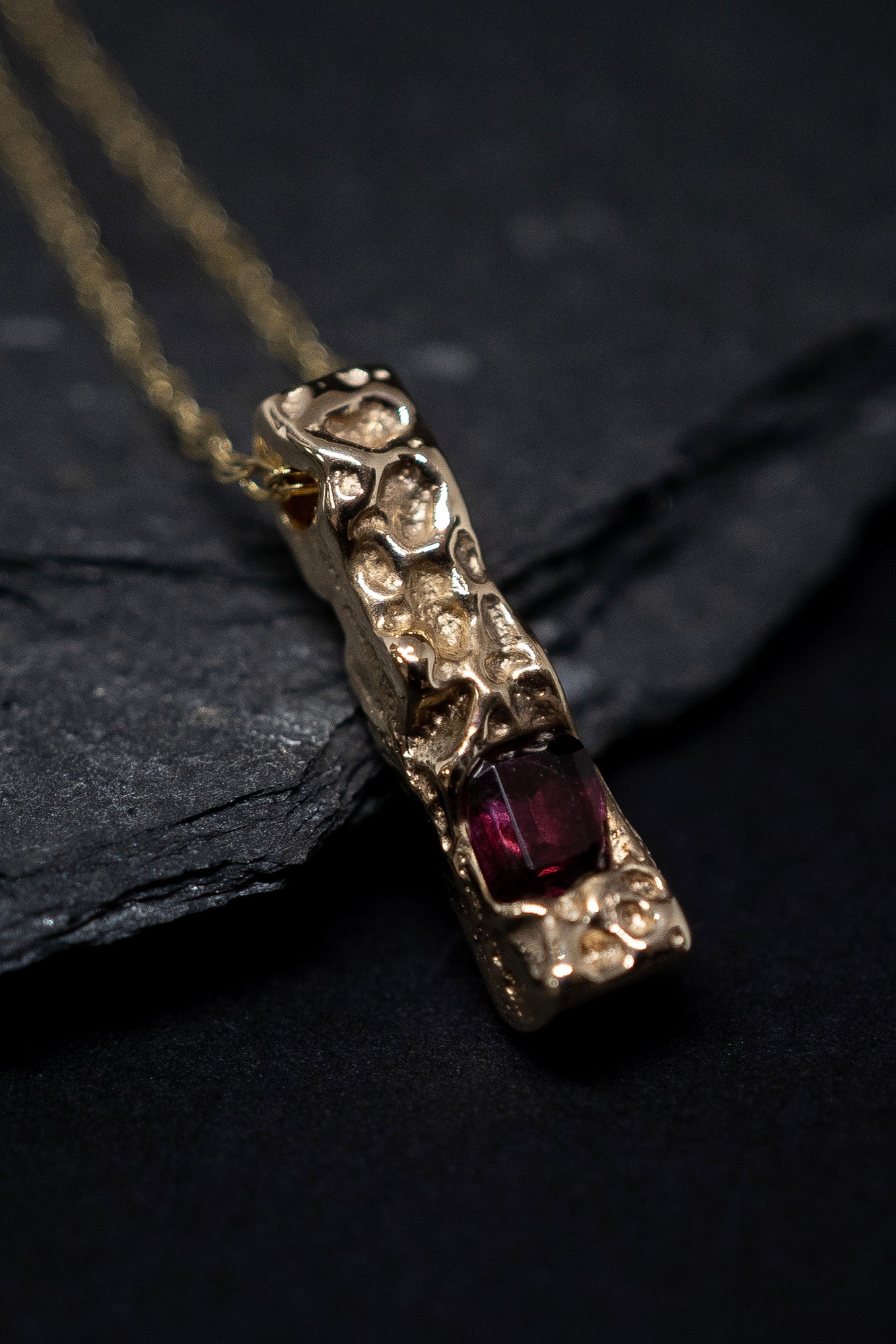 gold pendant with a cast in place garnet 